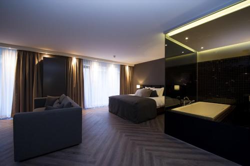 a hotel room with a bed and a bathtub and a bedroom at Van der Valk Hotel Sassenheim - Leiden in Sassenheim