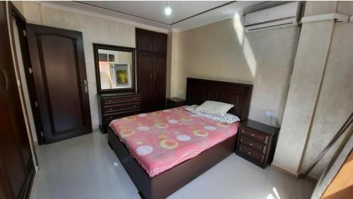 a small bedroom with a bed with a pink blanket at شقة الكرنيش in Nador