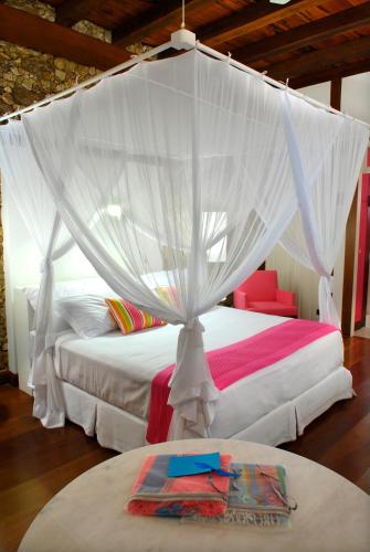 a bedroom with a bed with a canopy at Casa Turquesa - Maison D´Hôtes in Paraty
