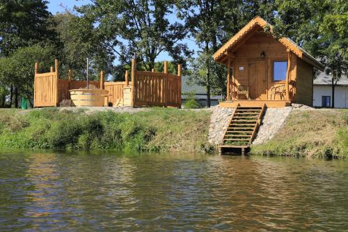 a wooden house on the bank of a river at Pensjonat Bajdarka in Suraż
