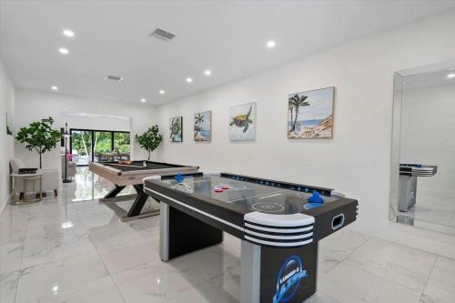 een woonkamer met een tafeltennistafel en een pooltafel bij VillaLee-Jungle Palm Island white marble pool Area in Miami