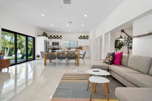 een woonkamer met een bank en een tafel bij VillaLee-Jungle Palm Island white marble pool Area in Miami