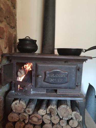 a wood stove with a pot on top of it at Mzila Forest Creek in Maanhaarrand