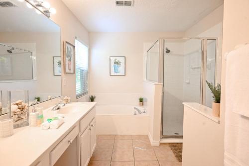 a bathroom with a tub and a sink and a shower at Golf getaway fun for family and friends for an Orlando theme park vacation in Davenport