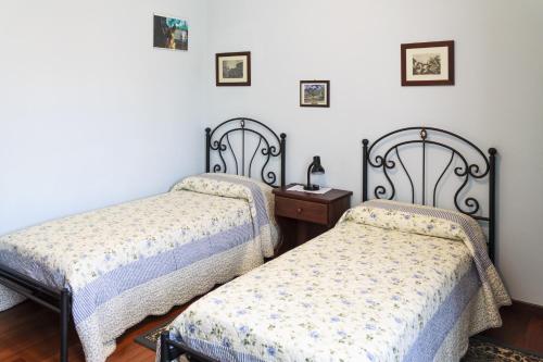 two twin beds in a room with a nightstand and a bed sidx sidx sidx at Ca' Livenza in Sacile