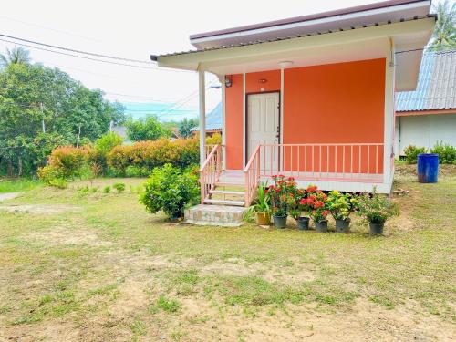 a house with a porch with flowers and plants at TR Bungalow in Ban Tha Rua