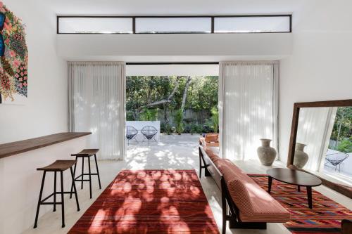 a living room with a red rug on the floor at Jungle Lodge Boutique Hotel - Adults Only in Chemuyil