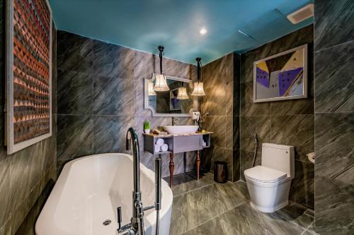a bathroom with a tub and a toilet and a sink at Son Hoi An Boutique Hotel & Spa in Hoi An