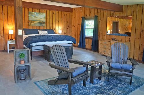 a bedroom with a bed and a desk and chairs at St Lawrence River Retreat in Ogdensburg