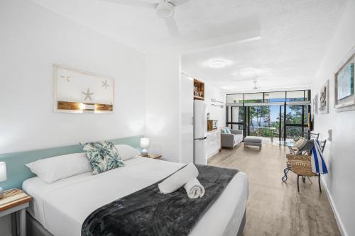 a bedroom with a bed and a living room at Amaroo At Trinity in Trinity Beach