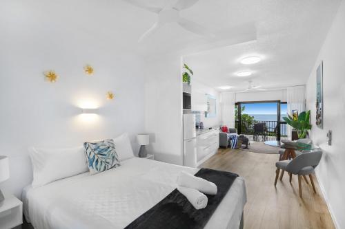 un soggiorno bianco con letto e cucina di Amaroo At Trinity a Trinity Beach