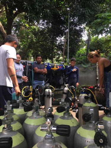 a group of people standing around a group of machines at La Tortue Diving Resort Dauin in Dauin