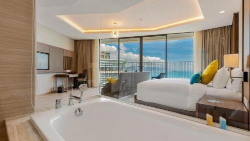 a bedroom with a bed and a tub in a room at Panorama Nha Trang Inn in Nha Trang