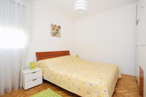 sypialnia z łóżkiem z żółtą kołdrą w obiekcie Holiday apartments Split - 11638 w Splicie