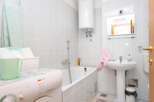 biała łazienka z umywalką i wanną w obiekcie Holiday apartments Split - 11638 w Splicie
