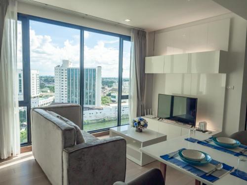 a living room with a table and chairs and a large window at WeLive Chiang Mai one bedroom, 42 Sqm. in Chiang Mai