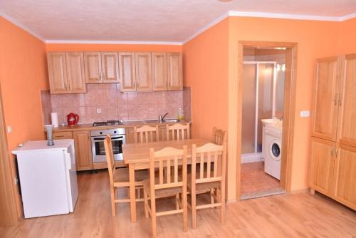 eine Küche mit einem Tisch und Stühlen sowie einem Kühlschrank in der Unterkunft Apartments with a parking space Stinjan, Pula - 11648 in Štinjan