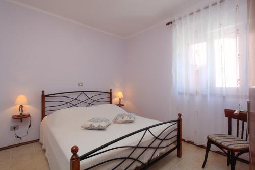 1 dormitorio con 1 cama, 1 silla y 1 ventana en Holiday house with a parking space Premantura, Medulin - 11631, en Premantura