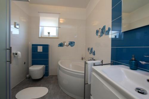 a bathroom with a tub and a toilet and a sink at Holiday house with a parking space Premantura, Medulin - 11631 in Premantura