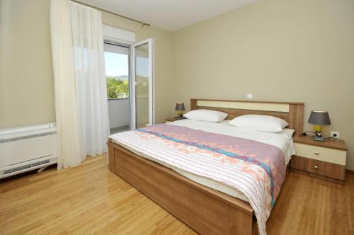 sypialnia z dużym łóżkiem i dużym oknem w obiekcie Apartments with a parking space Plano, Trogir - 11649 w Trogirze