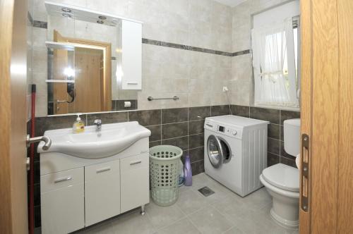 a bathroom with a sink and a washing machine at Apartments with a parking space Plano, Trogir - 11649 in Trogir