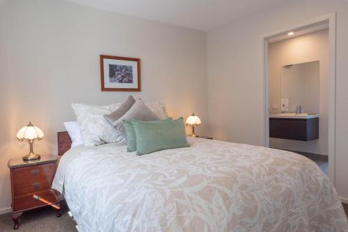 a bedroom with a large bed and a bathroom at 2 Oaks Cottage Clyde in Clyde