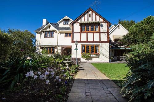 une grande maison blanche avec un chemin dans l'établissement Knightsbury Guest House, au Cap