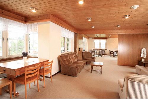 a living room with a couch and a table at Hotel am Schönenbühl in Speicher