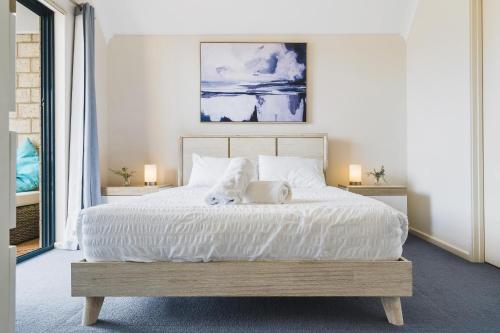 a bedroom with a white bed with two pillows at All Decked Out, Geographe Marina in Busselton