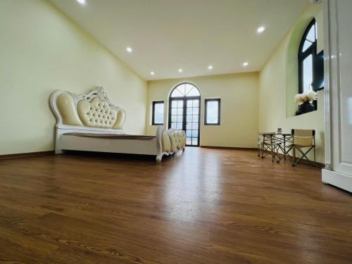 ein großes Wohnzimmer mit Sofa und Holzboden in der Unterkunft Villas Little White House Quê Vải in Ðào Lãng