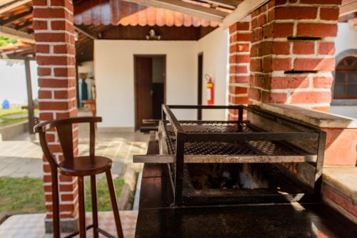 a chair sitting next to a fireplace on a patio at Pousada Tapera in Penedo