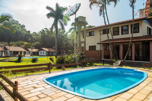 an image of a swimming pool in front of a house at Pousada Tapera in Penedo