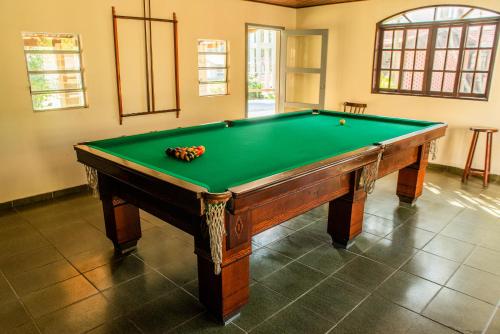 a green pool table with balls on top of it at Pousada Tapera in Penedo