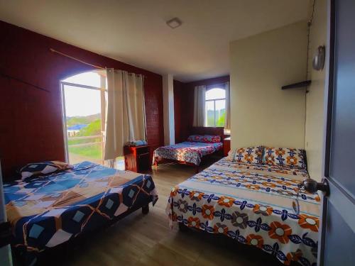 een slaapkamer met 2 bedden en een raam bij Hotel California in Montañita