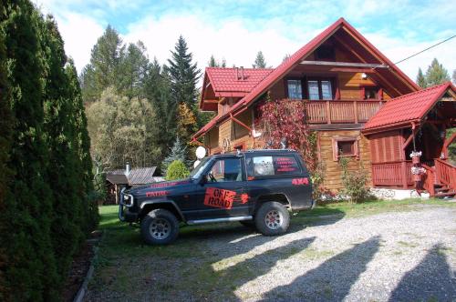 a black truck parked in front of a house at Dom Gościnny E-Lufka in Zawoja