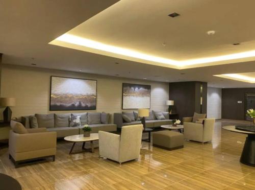 a living room with a couch and chairs and tables at Great View 1 BR Condo in Makati near Trident Tower in Manila