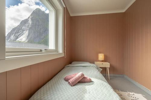 a small bedroom with a bed and a window at Reine Front View - Mountain & Seaview in Reine