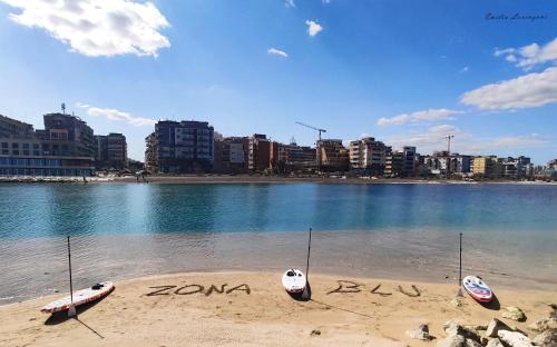 une plage avec deux bateaux écrits dans le sable dans l'établissement DOMUS RESIDENCE - CICERONE -, à Bari