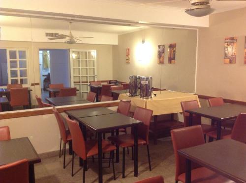 un ristorante con tavoli e sedie di Hotel Mitre a Rosario