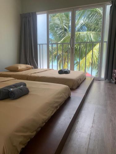 three beds in a room with a large window at WHITE SAND ARK RESORT in Koh Rong Island