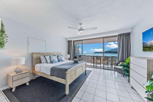 a bedroom with a bed and a view of the ocean at Ocean View Studio 49A in Airlie Beach