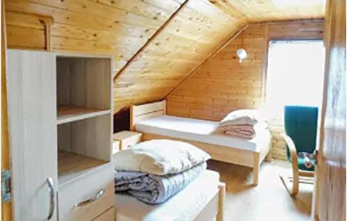 a room with two beds in a wooden cabin at Amazing Home In Kopalino With 3 Bedrooms in Kopalino