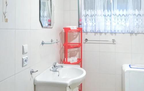 a white bathroom with a sink and a red shelf at Amazing Home In Kopalino With 3 Bedrooms in Kopalino