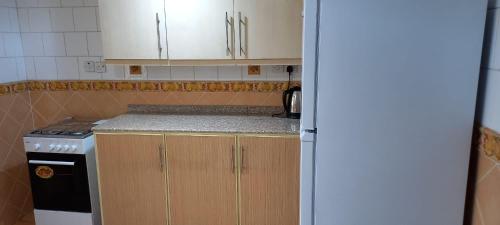 a kitchen with white cabinets and a stove at Gulf Continental Suite in Kuwait