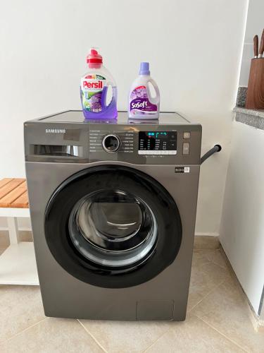 a washing machine with two detergent bottles on top of it at Kijani Paradise Malindi in Malindi