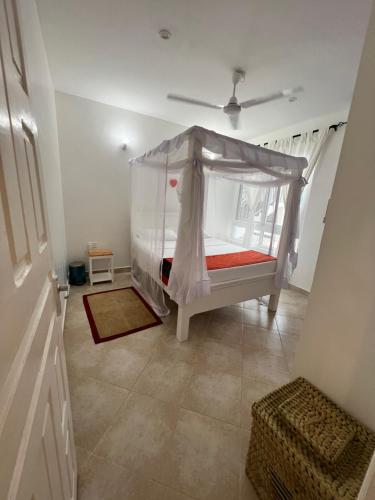 a bedroom with a bed with a canopy at Kijani Paradise Malindi in Malindi