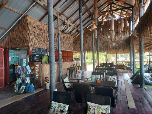 a restaurant with tables and chairs in a building at Cliff Cottage in Ko Chang