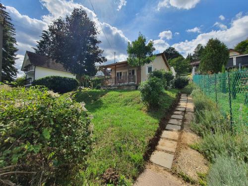 a yard with a house and a fence at Orfűi Kisház in Orfű