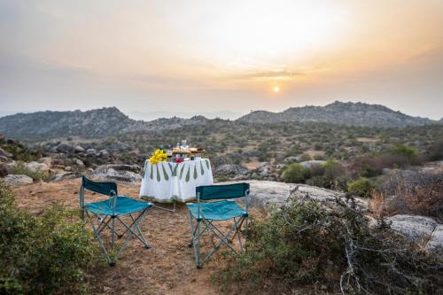 a table and chairs sitting on top of a hill at Sariska Manor Luxury Cottages Tehla in Tehla