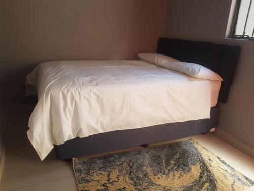 een bed in een kamer met een tapijt en een bed sidx sidx sidx bij Poblar's Bed & Breakfast in Soweto